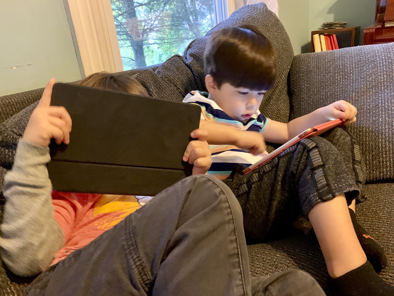 Two kids giving iPads deep attention